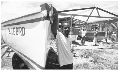 Shipwright David Hodge, known for building some of the fastest boats in Anguilla, stands by one of the boats he has built by hand.