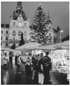 Customers explore the shops in the open-air Christmas Market at Hauptplatz in Graz.