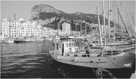 Fishing boats fill the harbor below the Rock of Gibraltar.