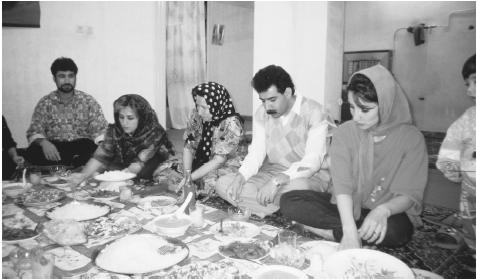 An Iranian family eating a meal in Shiraj. Even after they leave home, members of extended families have hospitality rights in the homes of their most distant relatives.
