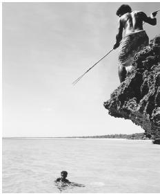 Man fishing from a rock ledge; fish is a national ceremonial food.