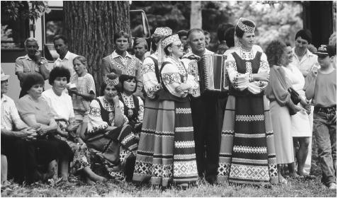 Musicians in traditional Polish costume perform folk music during Swieto Ludowe. The festival commemorates the founding of the town of Narweka.