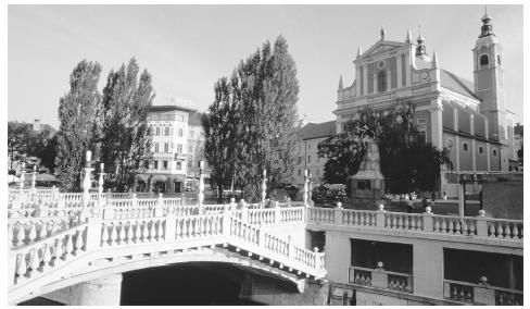 A bridge leading to a Baroque-style church in Ljubljana. Slovenia's towns have many well-preserved buildings representing various styles of architecture dating from the 1100s on.