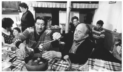 A family enjoys vin cau, or mulled wine, after a large family meal. Meals, especially the midday comida and late-evening cena, are important gathering times in Spain.